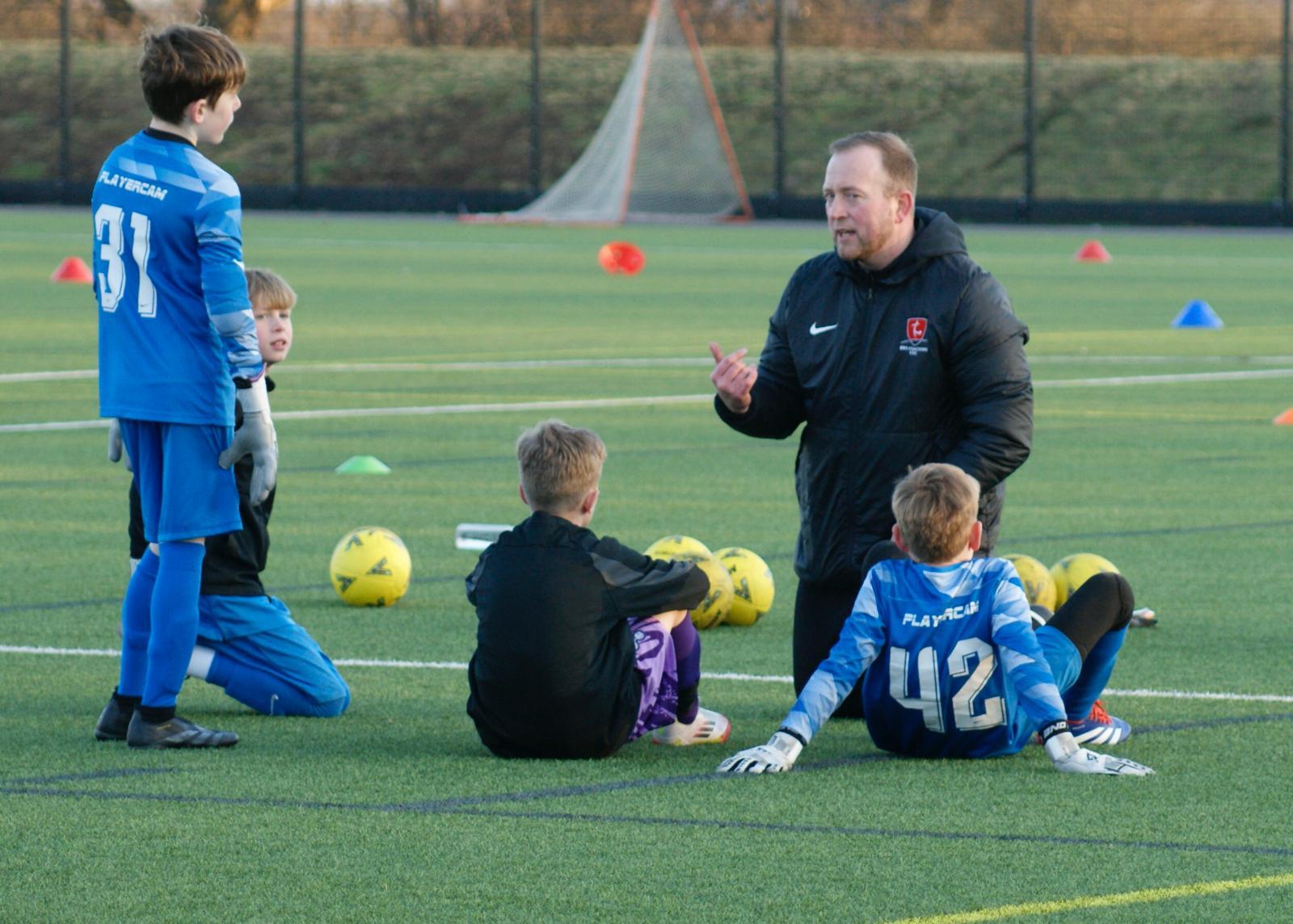 A BRS coach leading a training session with young players